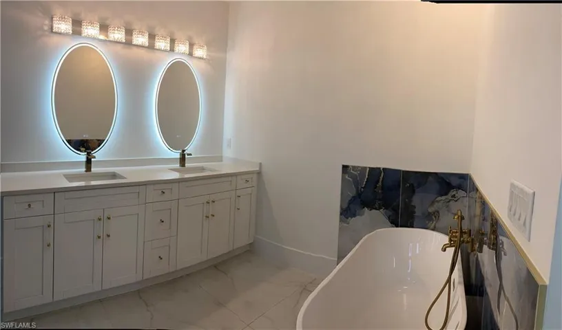 Bathroom featuring a tub to relax in and vanity