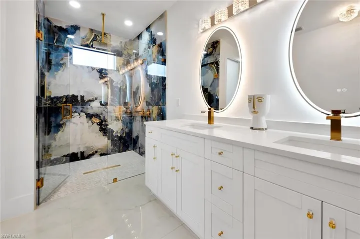 Bathroom featuring a tile shower and vanity