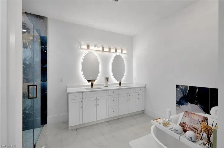 Bathroom featuring vanity and a shower with door