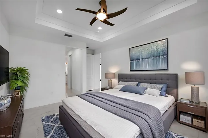 Bedroom featuring ceiling fan and a tray ceiling