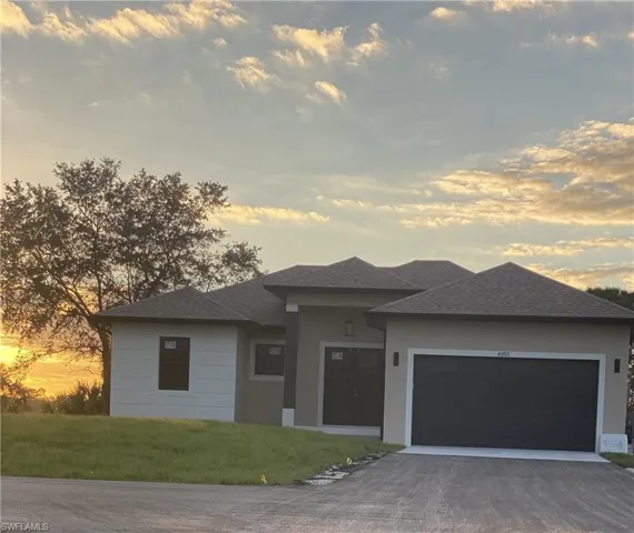 Prairie-style house featuring a garage and a yard