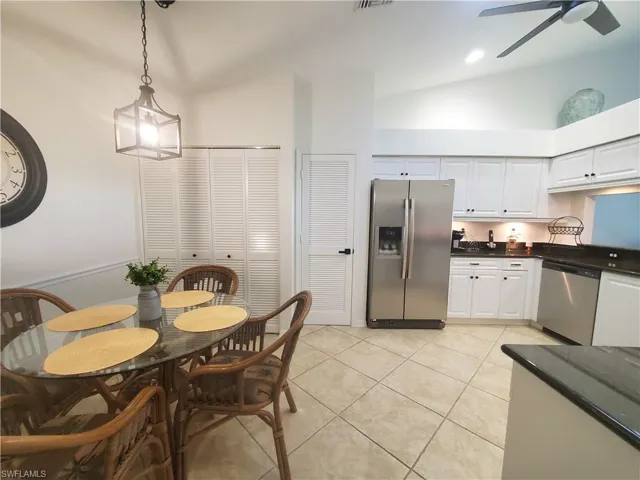 Dining area featuring high vaulted ceiling, ceiling fan, and light tile floors