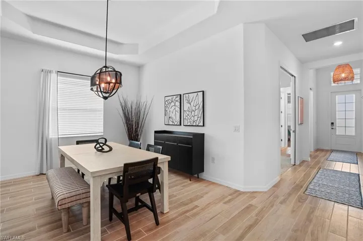 Dining room featuring wood tiled floors, a tray ceiling, and a chandelier