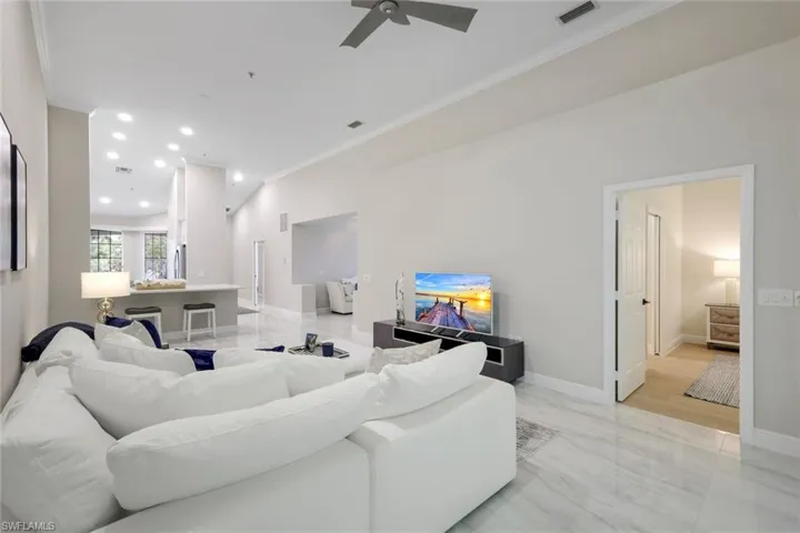 Living room with crown molding and ceiling fan