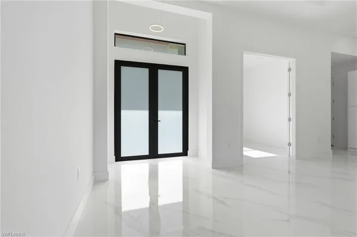 Entryway featuring a large black framed double door with frosted glass, transom window, and a circular overhead light fixture