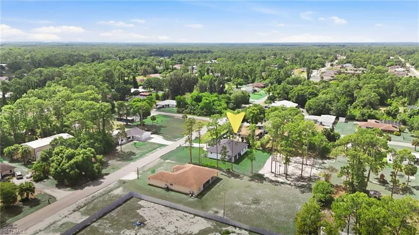 Property situated on a spacious lot, featuring a dark shingle roof and a concrete driveway