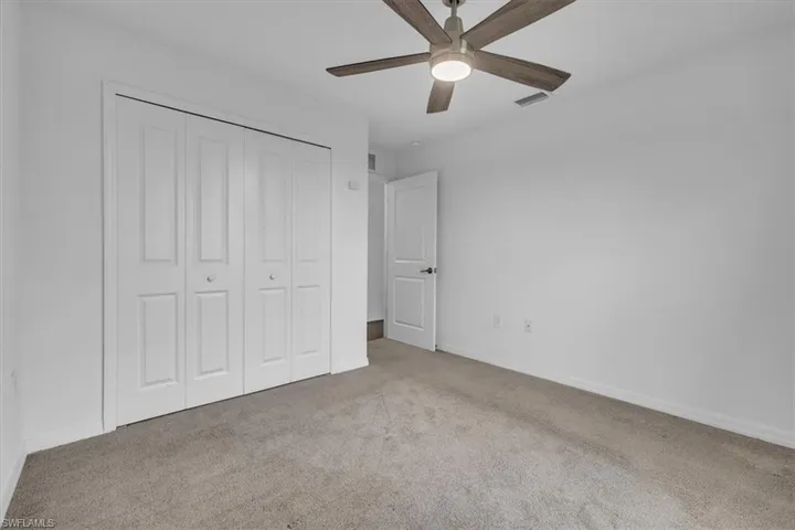 Unfurnished bedroom with carpet floors, a closet, and a ceiling fan