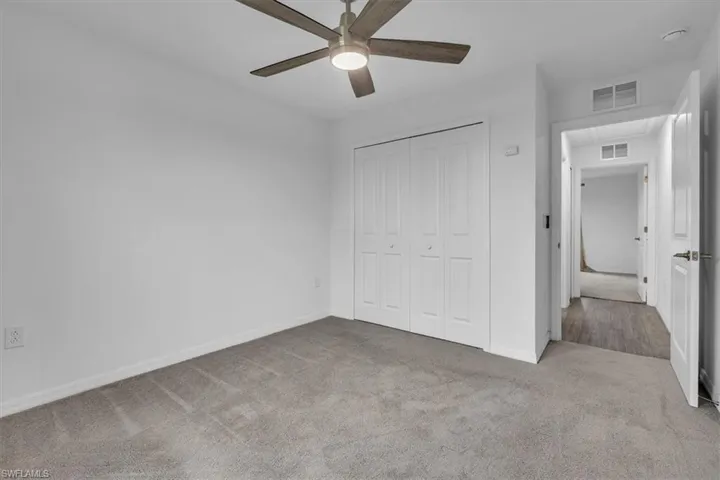 Unfurnished bedroom with light colored carpet, a closet, and ceiling fan
