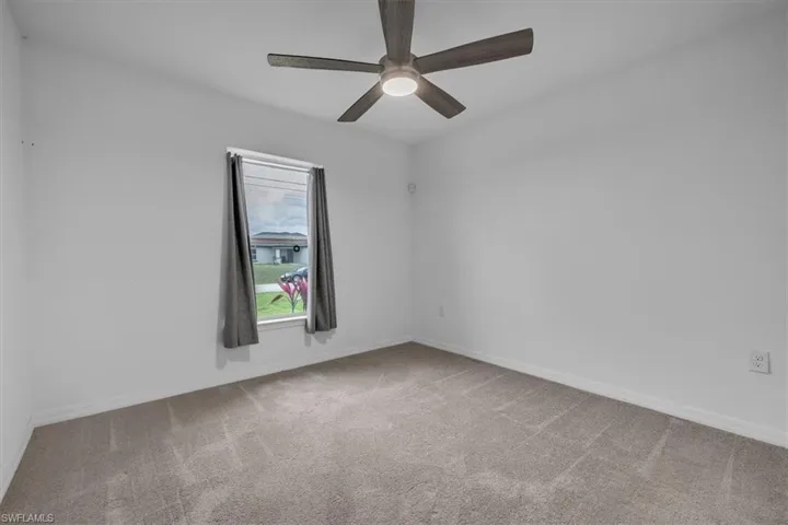 Unfurnished room with light carpet and ceiling fan