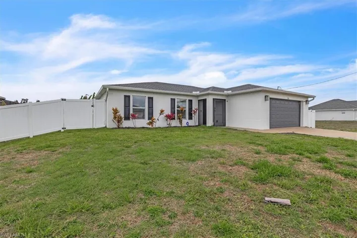 Ranch-style home with a gate, a garage, stucco siding, and concrete driveway