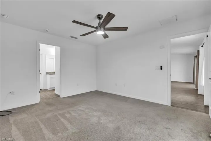 Empty room with light carpet and ceiling fan