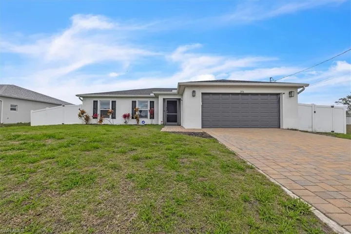 Single story home featuring a gate, stucco siding, decorative driveway, and an attached garage