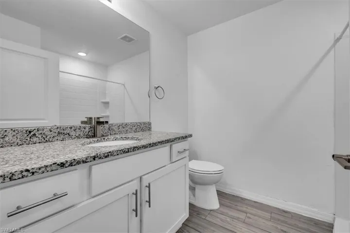 Bathroom featuring vanity, light wood-style floors, and a shower