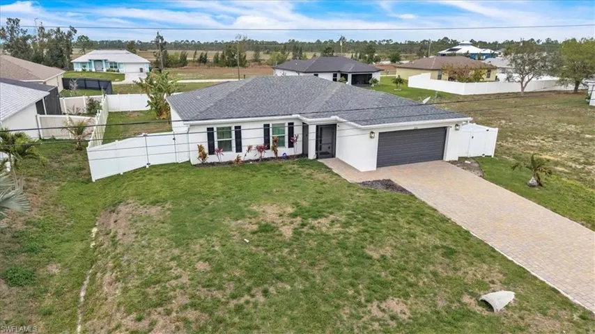 Ranch-style house with an attached garage, decorative driveway, stucco siding, a shingled roof, and a residential view
