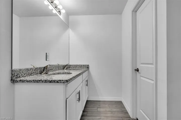 Bathroom with double vanity and light wood-style floors