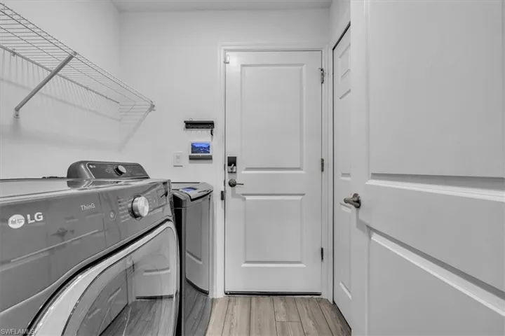 Laundry area featuring light wood finished floors and separate washer and dryer