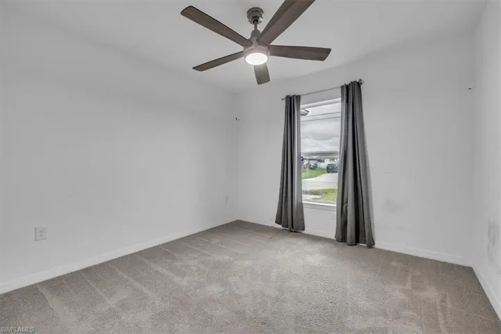 Empty room with light carpet and ceiling fan