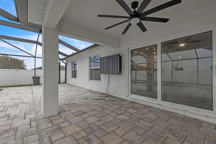 View of patio featuring a sunroom, glass enclosure, and ceiling fan