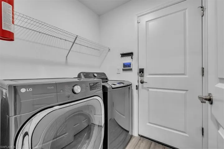 Laundry room featuring light wood-style floors and separate washer and dryer