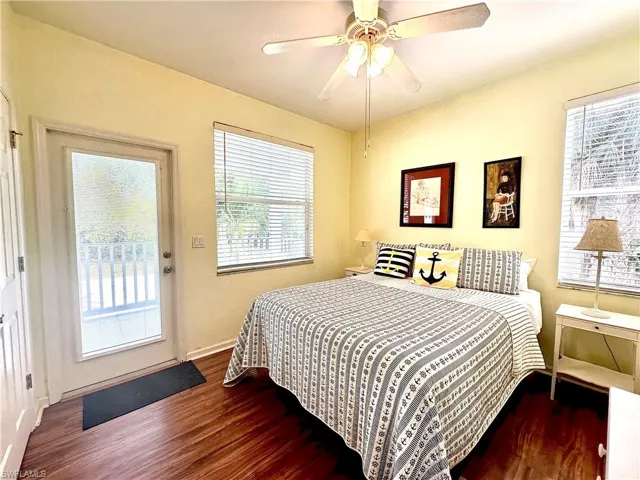 Guest Bedroom on the main level features dark wood-style flooring, access to lanai, and ceiling fan