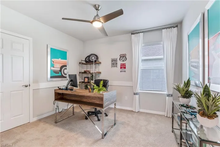Home office with light carpet, plenty of natural light, and ceiling fan