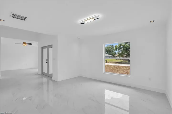 Tiled spare room featuring ceiling fan