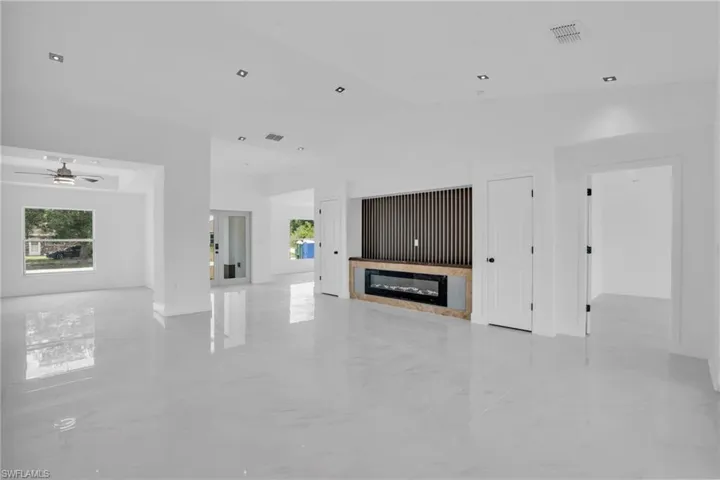 Unfurnished living room with ceiling fan and light tile floors