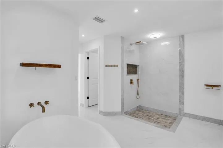 Bathroom with a tile shower and tile floors