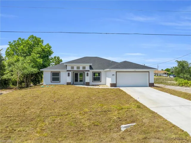 View of front of house with a front yard and a garage