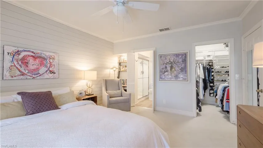 This view of the Master Bedroom includes a peek into the walk-in closet, the built in bookcase/desk area with added downlighting, shiplap accent wall, and recently updated en-suite bathroom.