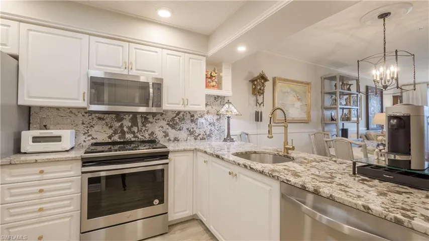 Beautifully updated kitchen w/downlights, granite countertops and backsplash, stainless steel appliances, and high-end designer touches like the gooseneck faucet, cabinet pulls and beadboard ceiling. 2025 premium induction range.