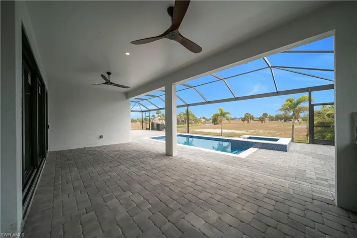 View of swimming pool featuring glass enclosure, a patio, a sunroom, and a pool with connected hot tub
