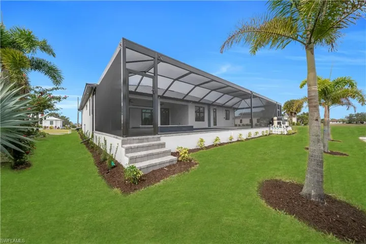 Rear view of property featuring glass enclosure, a yard, a sunroom, and a patio area