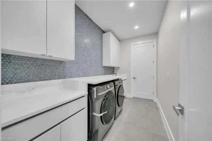 Laundry room featuring cabinet space, recessed lighting, and washing machine and dryer