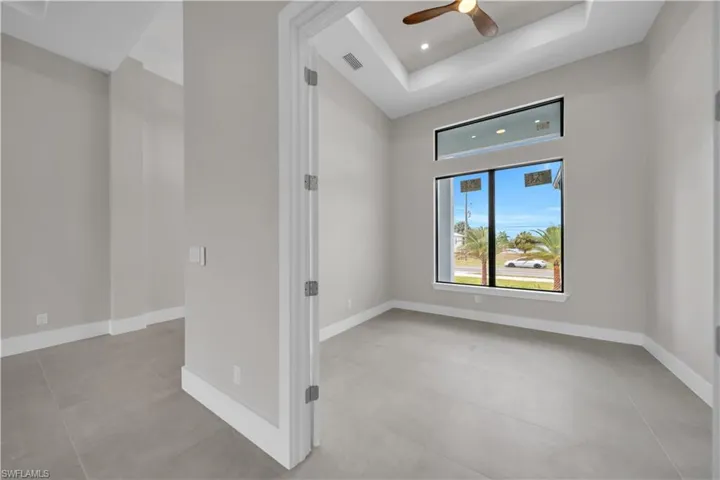 Empty room with recessed lighting, a ceiling fan, a tray ceiling, and concrete flooring