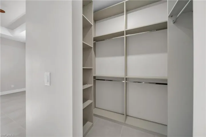 Spacious closet with light tile patterned floors
