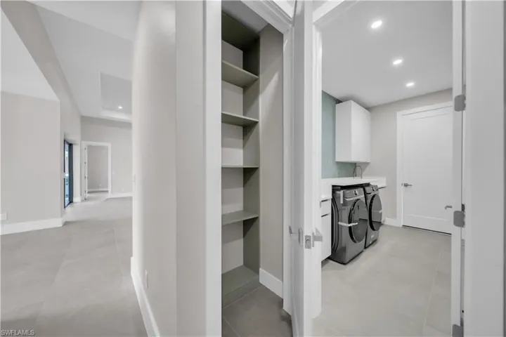Hall with recessed lighting and separate washer and dryer