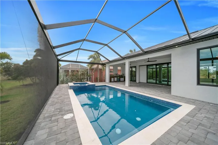 View of swimming pool with a sunroom, a lanai, a pool with connected hot tub, and a patio area