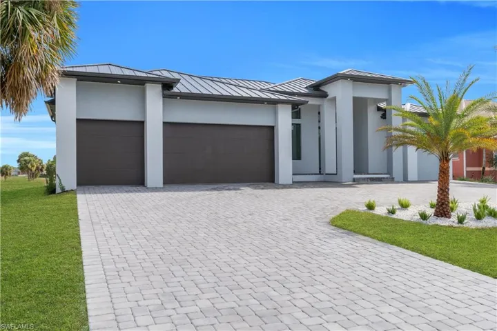 View of front of house featuring a standing seam roof, a metal roof, and decorative driveway