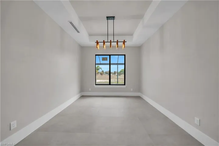 Spare room with a raised ceiling and concrete flooring