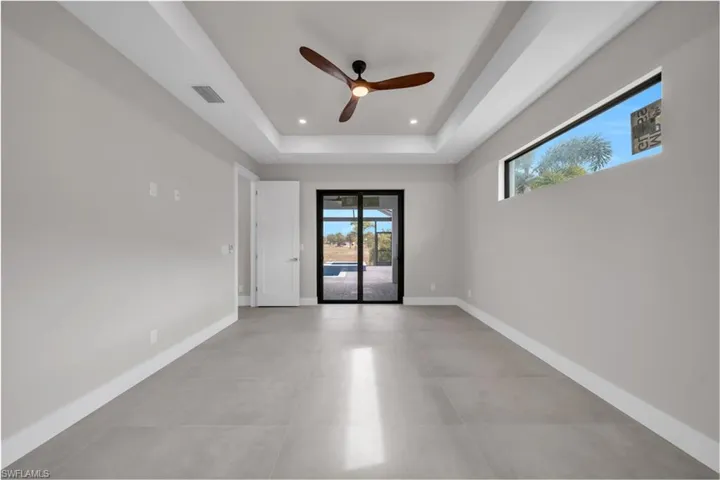 Spare room with a raised ceiling, ceiling fan, and recessed lighting
