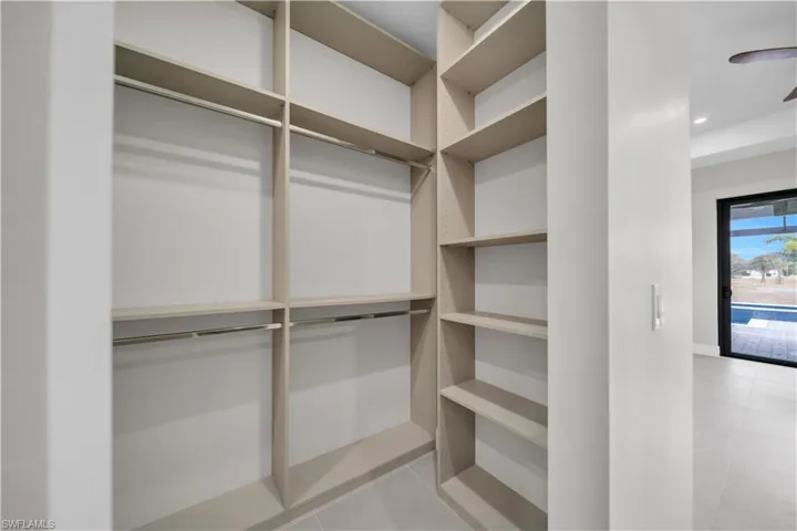 Walk in closet with ceiling fan and light tile patterned flooring