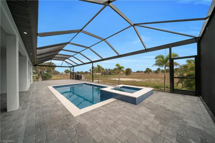 View of pool with a sunroom, a patio, a lanai, and a pool with connected hot tub