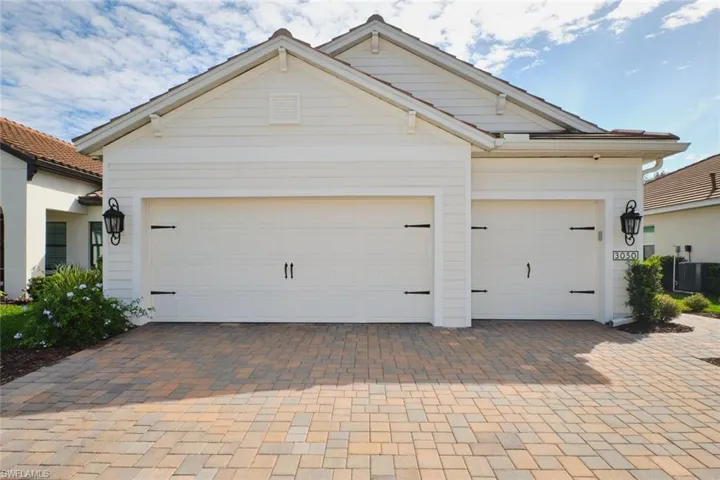 View of front of house with decorative driveway and a garage