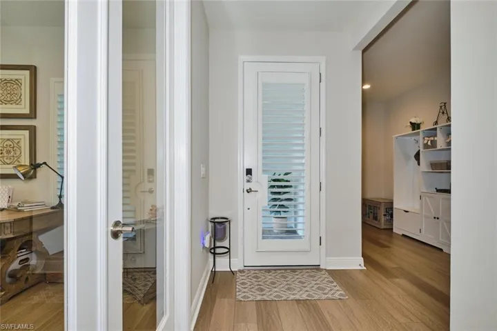 Doorway with wood finished floors and recessed lighting