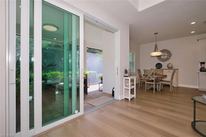 Doorway to outside with wood finished floors and recessed lighting