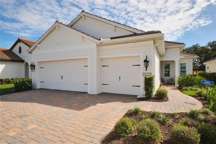 View of front of house with decorative driveway and an attached garage