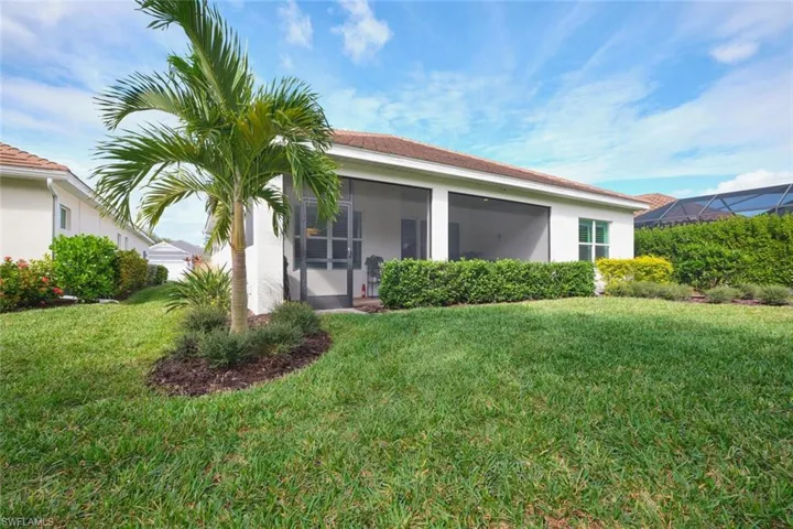 Back of house featuring a sunroom, stucco siding, and a lawn