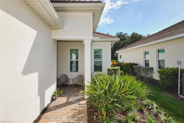 Property entrance with stucco siding, a patio, and a tiled roof