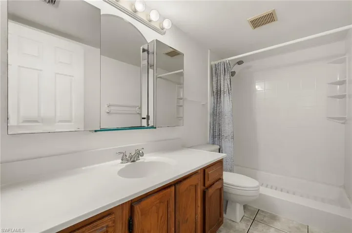 Bathroom with tile patterned floors, vanity, toilet, and walk in shower
